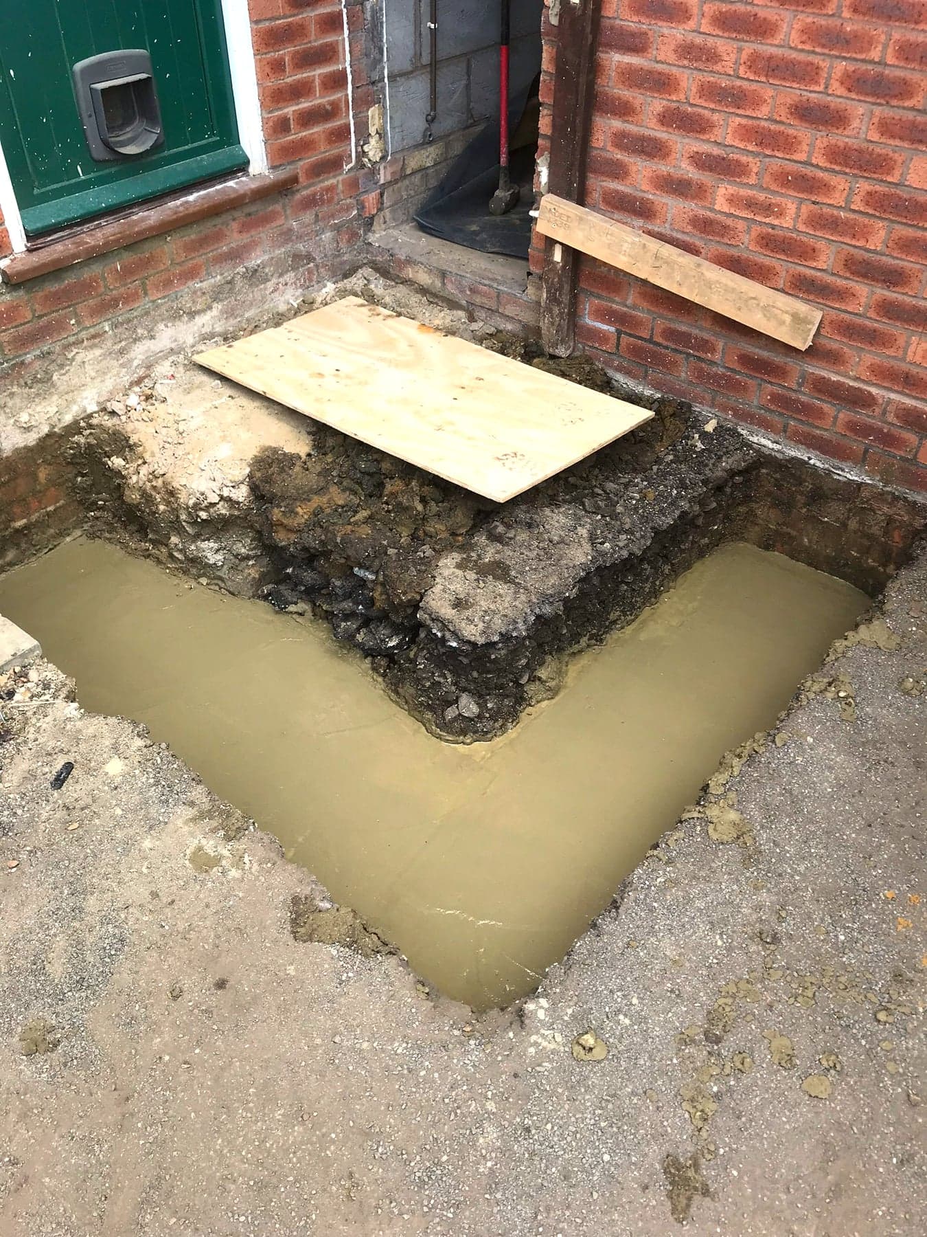 Trench-fill concrete foundation poured against the existing wall, London extension