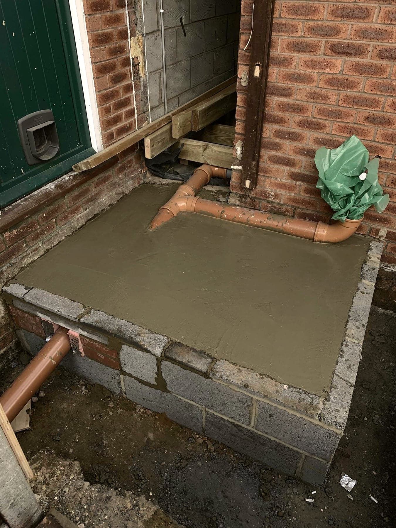New concrete slab poured with soil pipe and drainage connections, London extension