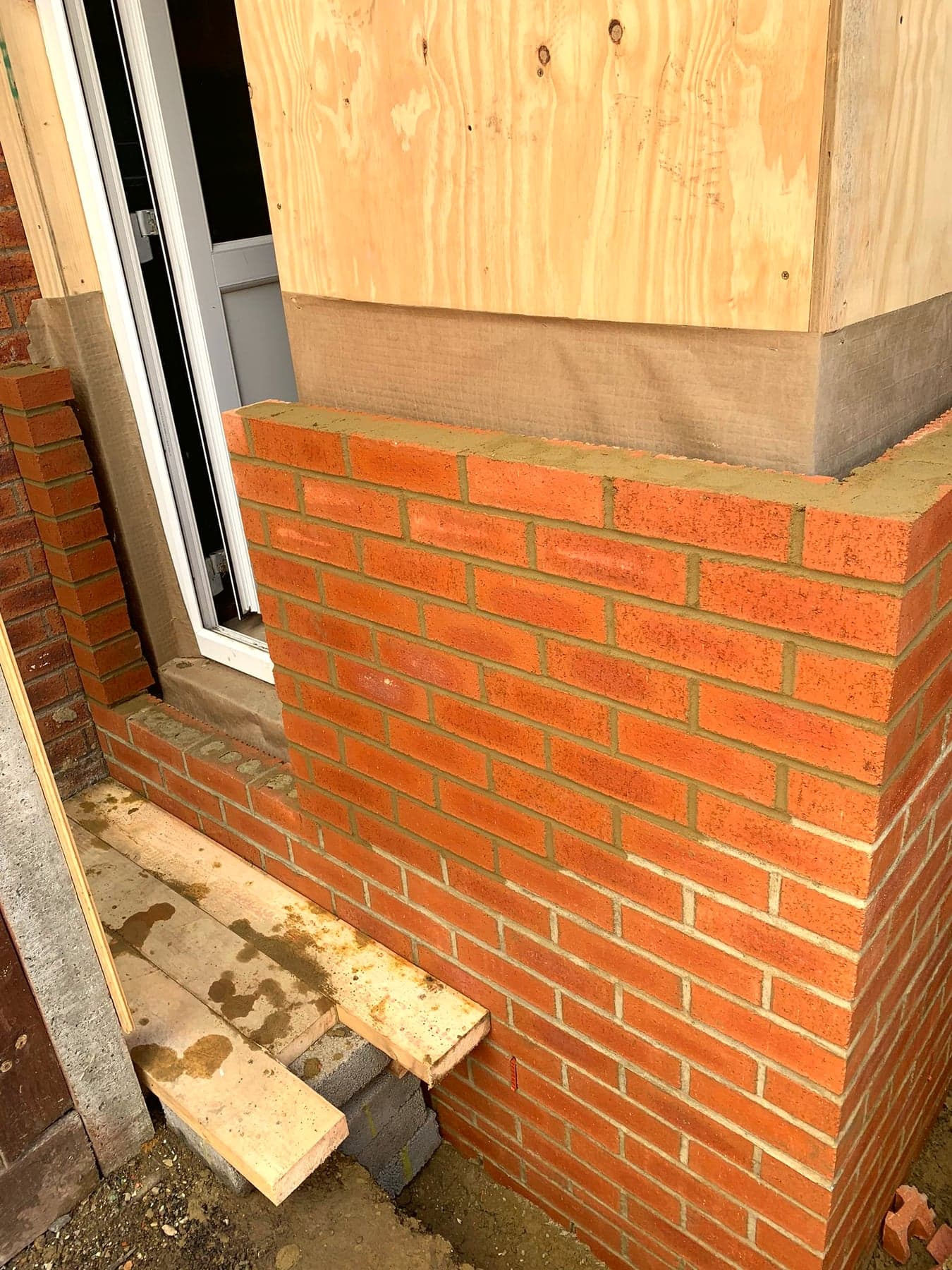 New brick pier built alongside the window opening, London extension
