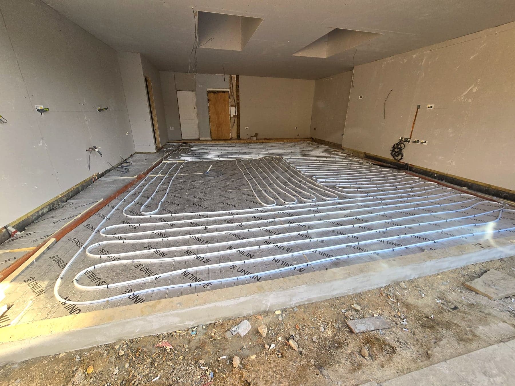 Underfloor heating pipes laid across the new floor before screed, London extension
