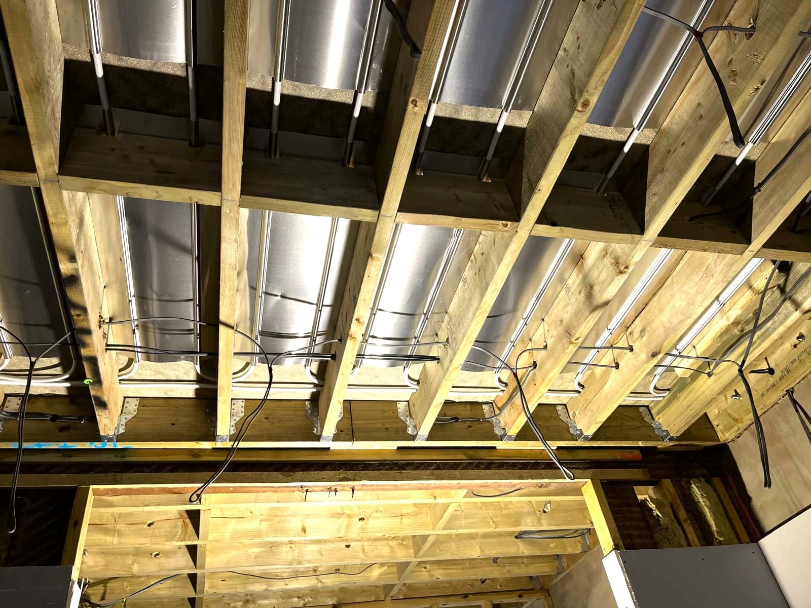 Insulated ducting and first-fix cabling routed through the ceiling void, London extension