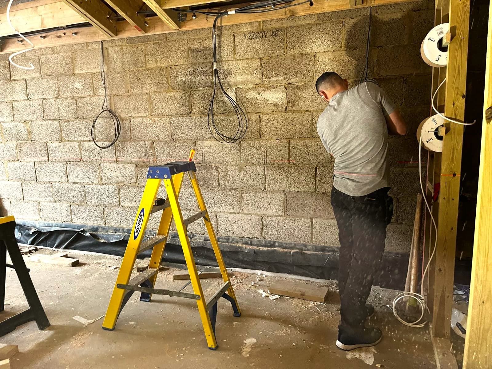 Electrician running first-fix cabling in a new extension, London