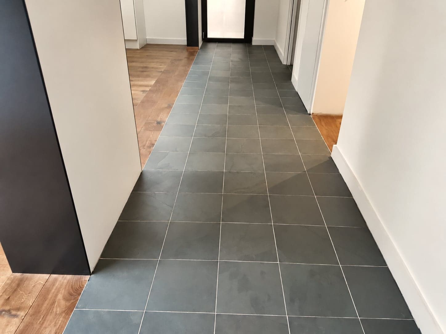 Finished hallway with slate tiled floor meeting oak flooring, London extension