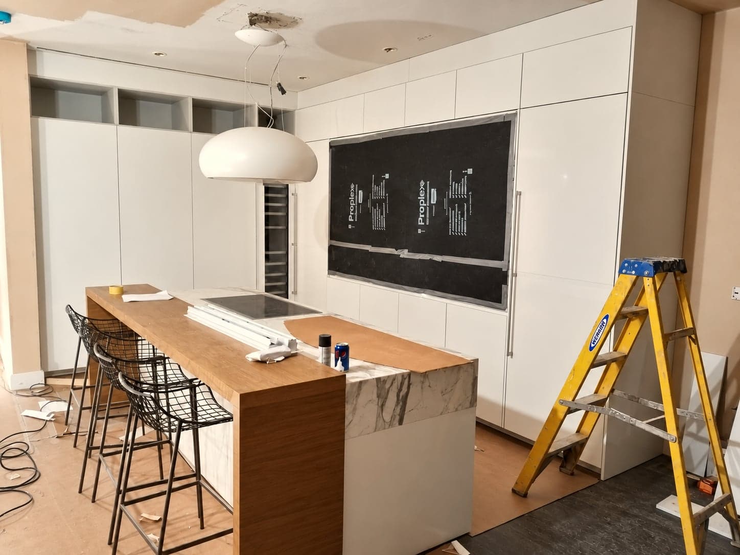 Kitchen units and island being fitted in a new extension, London