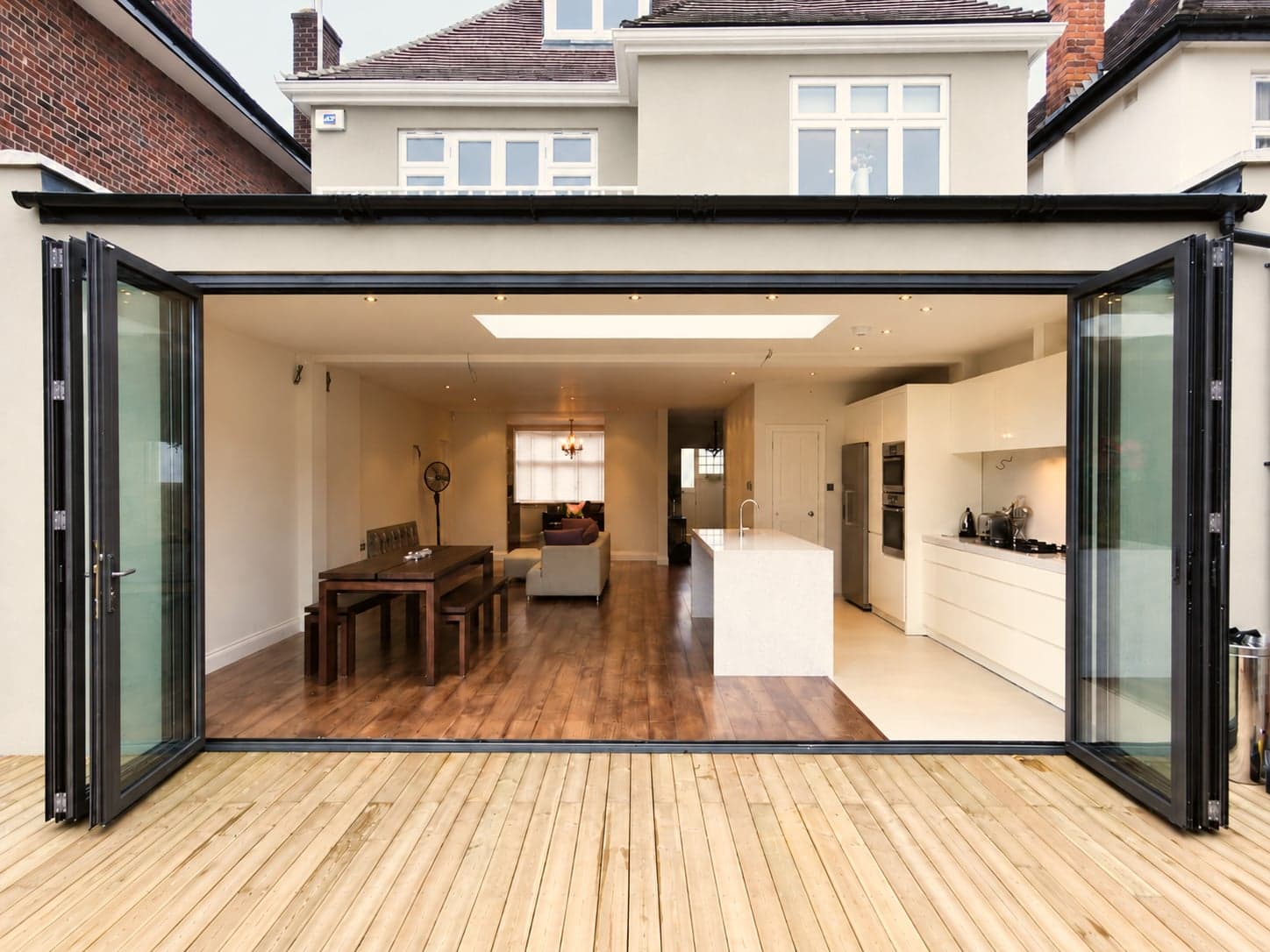 Completed open-plan kitchen extension seen through bi-fold doors from the garden, London