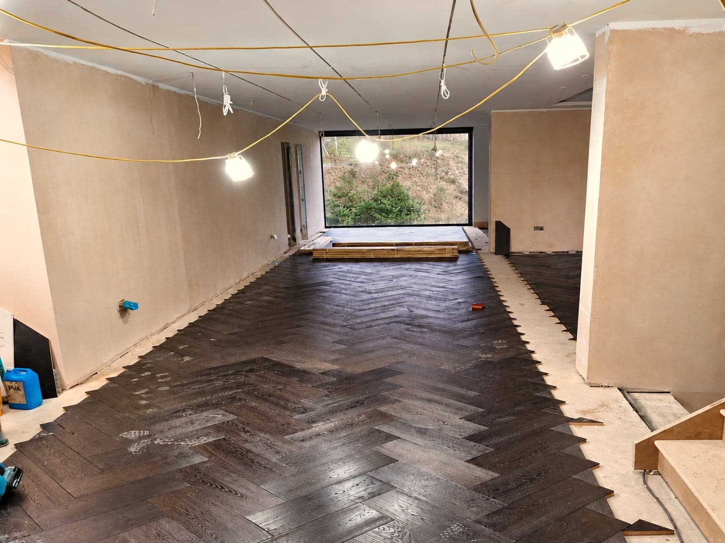 Herringbone wood flooring being laid in a new extension, London