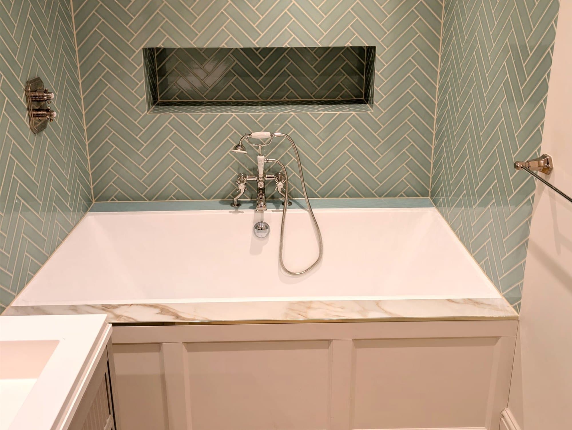 Bathroom with sage herringbone tiling, a marble-topped panelled bath and nickel bath-shower mixer, Fulham SW6