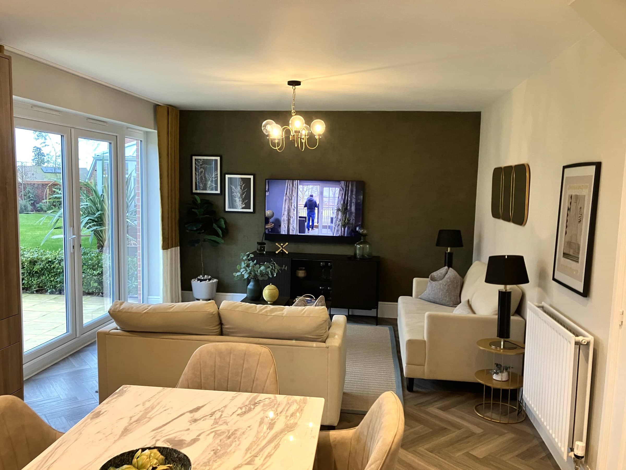 Finished living and dining room renovation with olive feature wall, London
