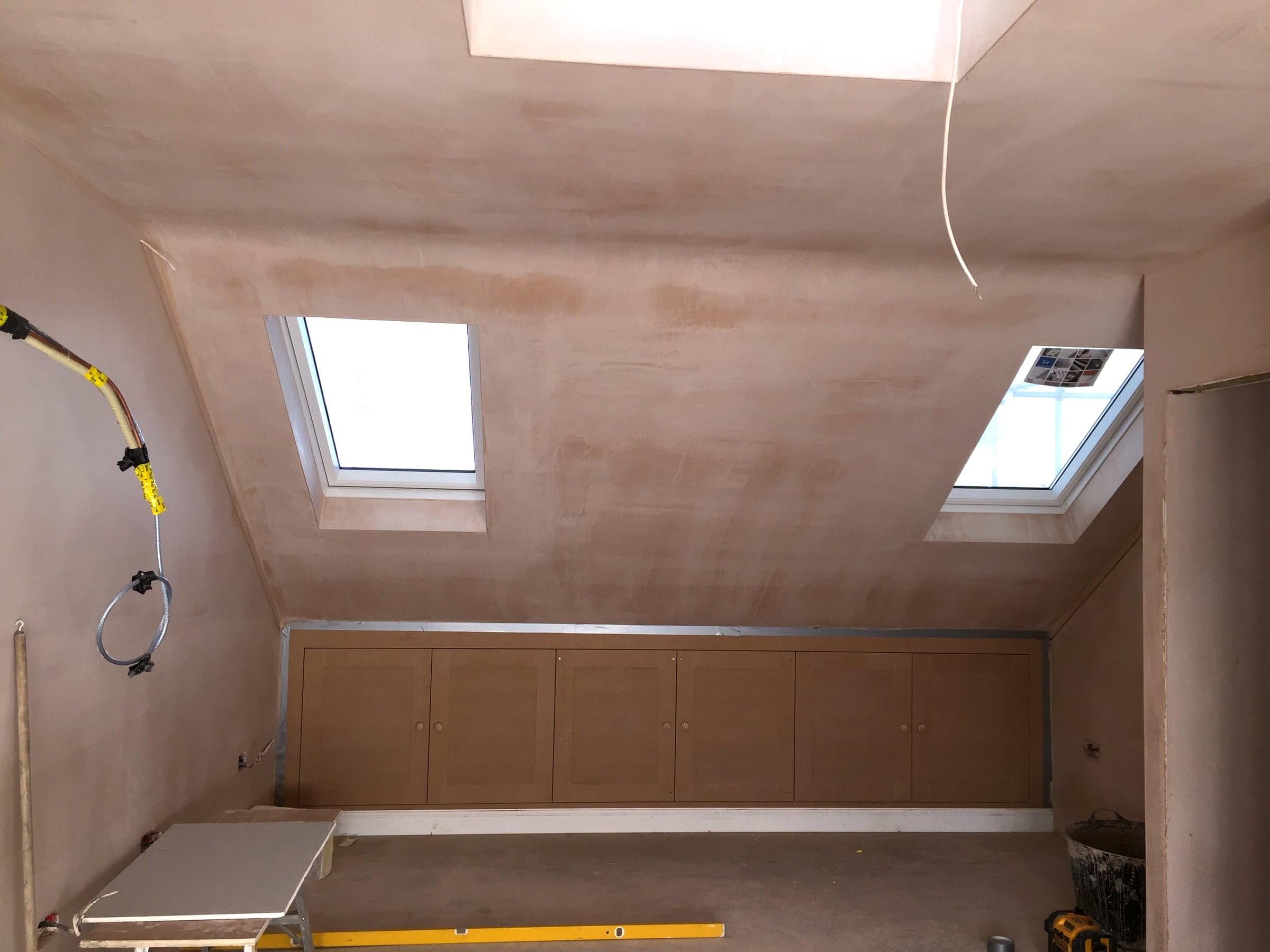 Under-purlin storage with finished skim coat, London loft conversion