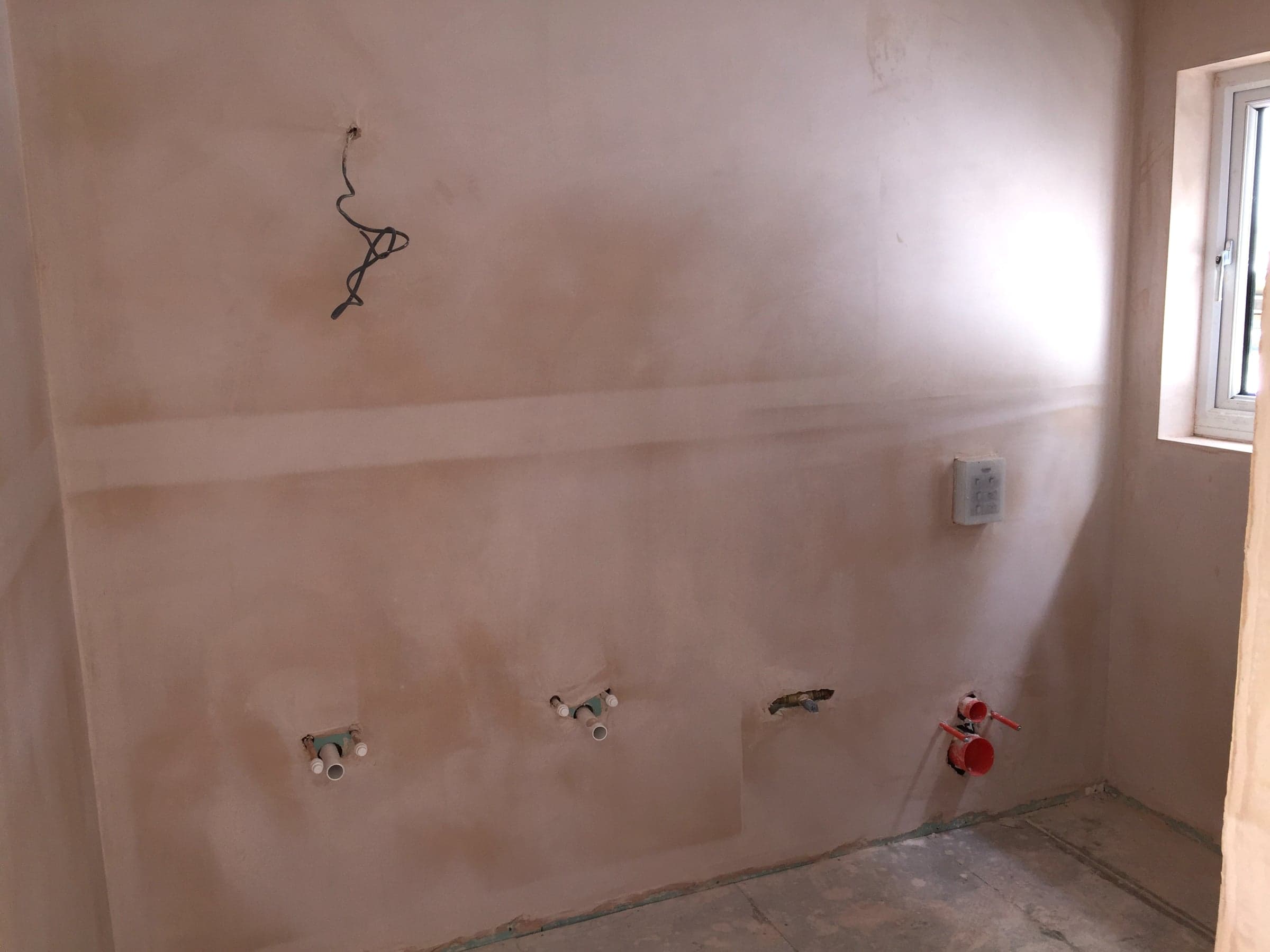 Plumbing stub-outs set into finished plaster, London loft conversion