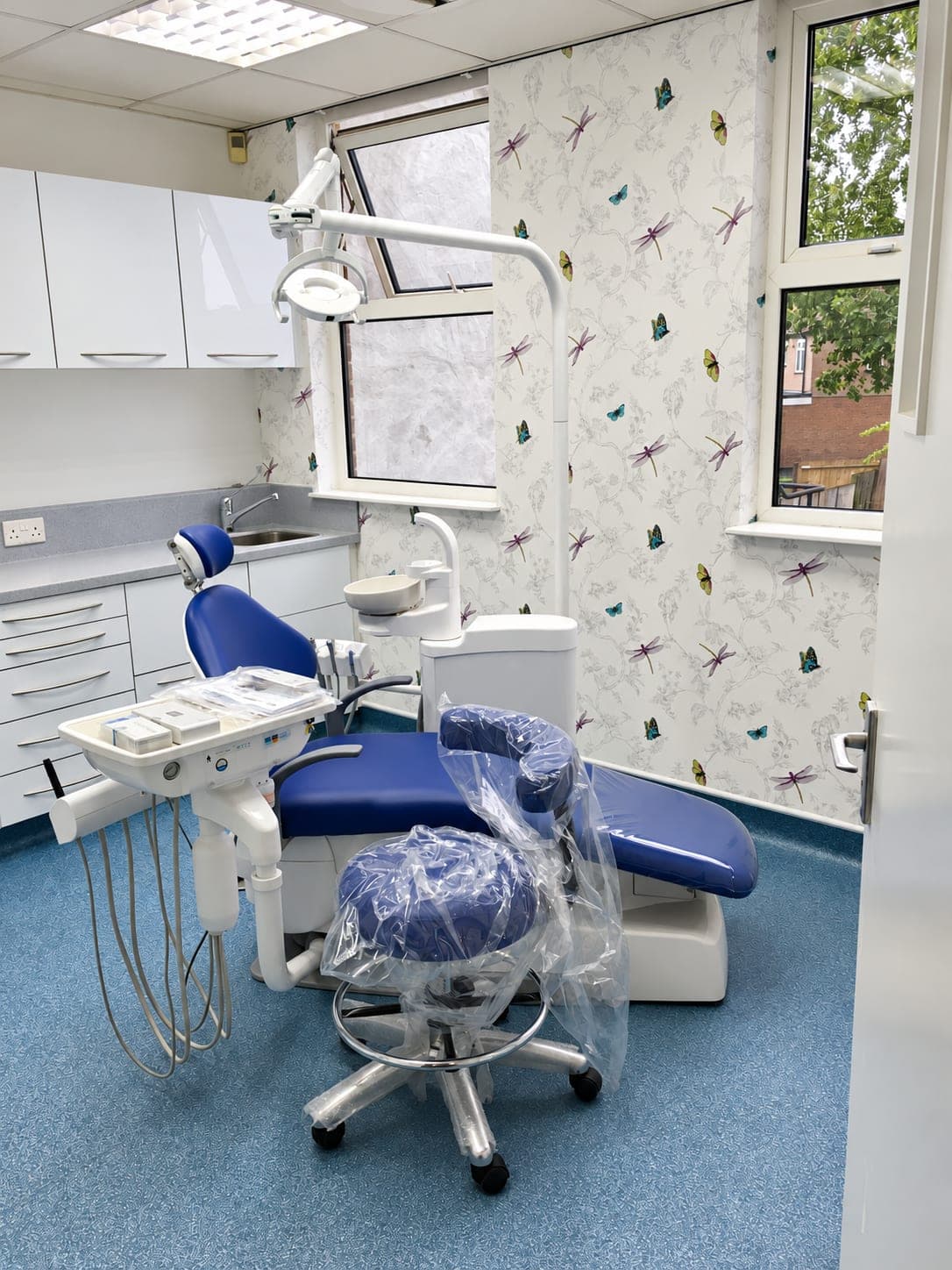 Refurbished dental surgery with blue chair, white cabinetry and blue safety vinyl flooring, Belmont Circle HA3