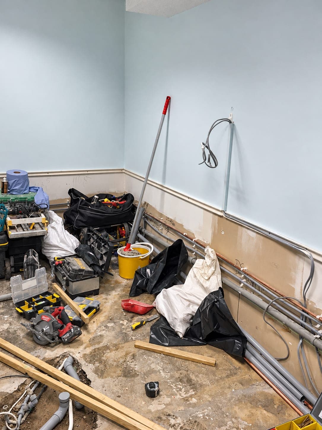 Mid-strip-out with the floor open and first-fix services being run, Bishopsgate EC2