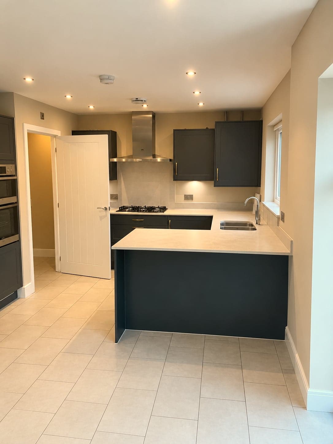Kitchen and peninsula seen from the hall doorway, tiled flooring throughout, North Finchley N12