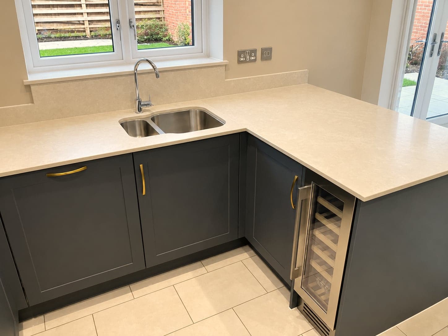 L-shaped run with sink, wine cooler and quartz worktop beside the garden doors, North Finchley N12