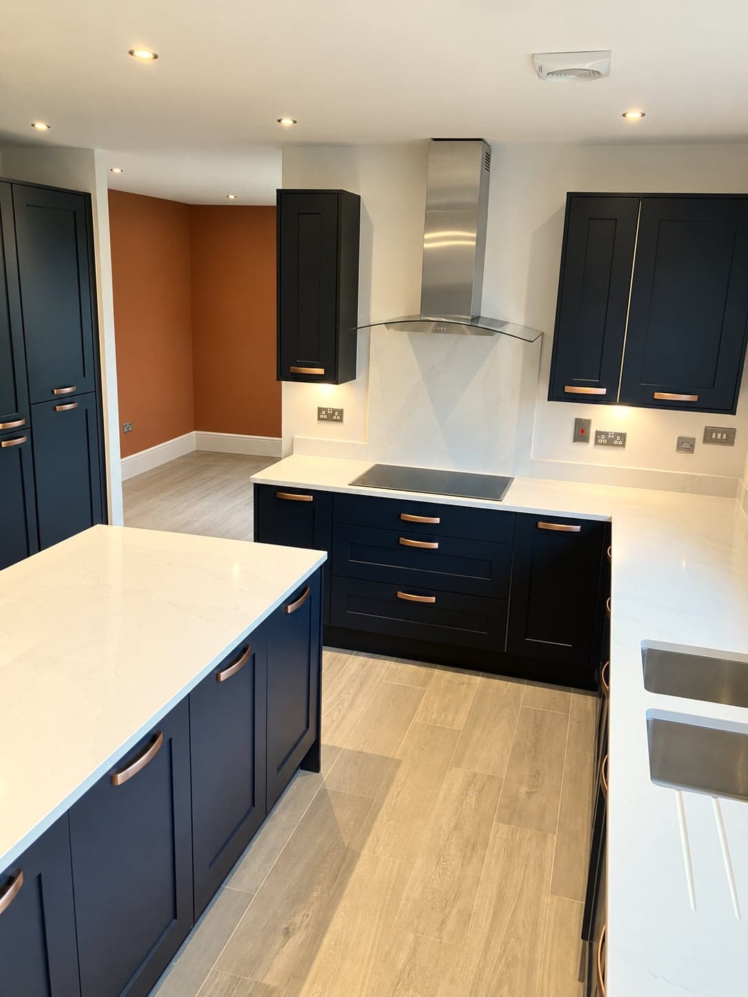 Kitchen and dining space together, island, hob run and terracotta feature wall, Notting Hill W11