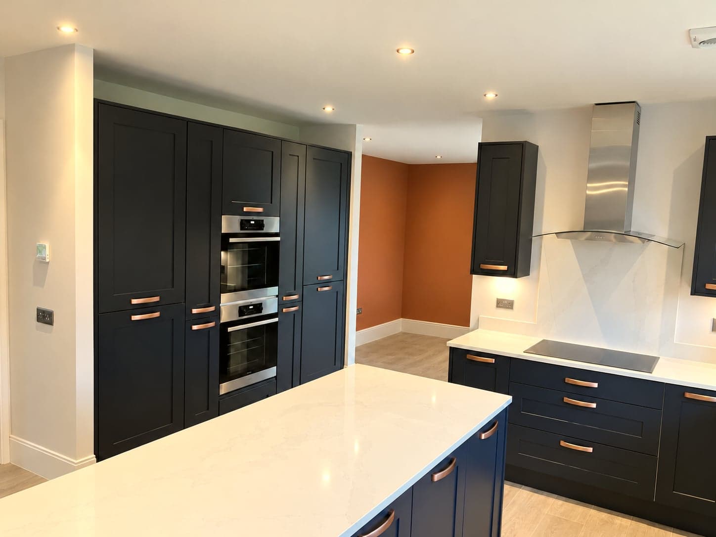 Charcoal tall units and oven tower against the terracotta wall, Notting Hill W11