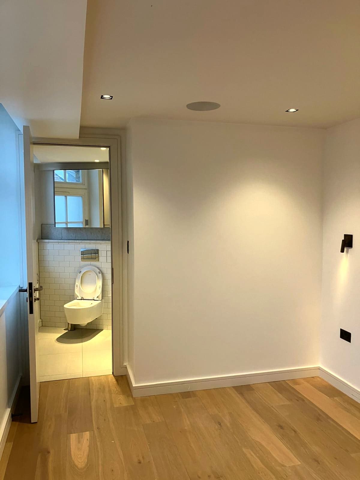 Looking through from the bedroom to the finished bathroom across new oak flooring, Camden NW1