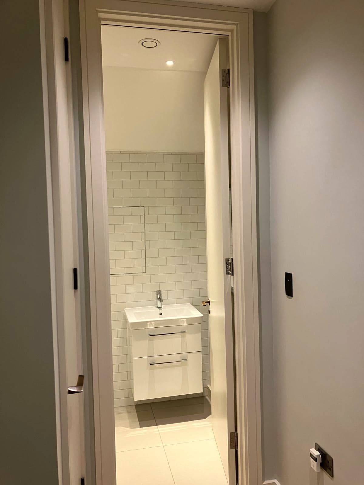 En-suite doorway with the vanity and metro tiling beyond, Marylebone W1