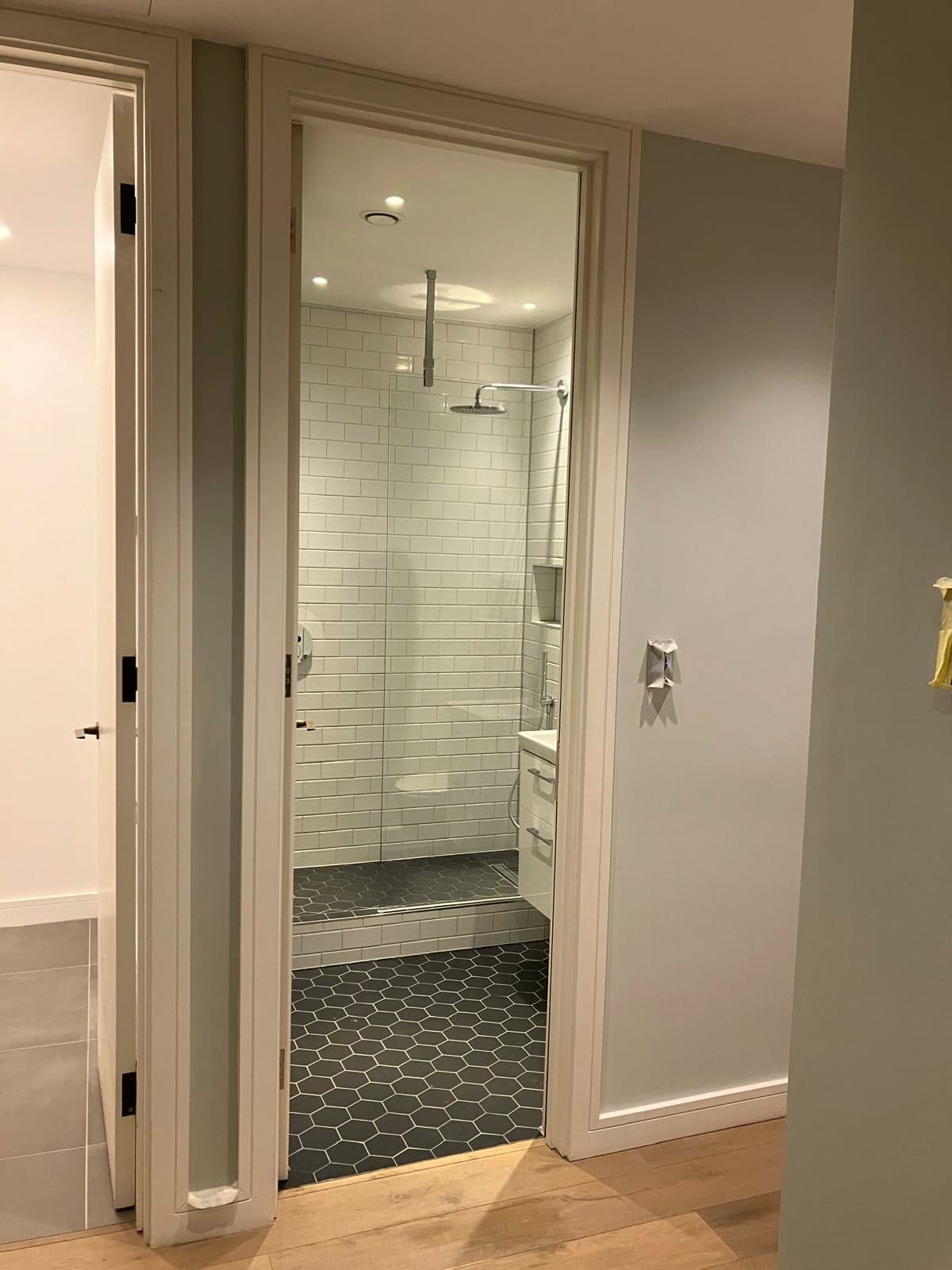 En-suite seen through the open door with the shower and hexagonal floor visible, Marylebone W1