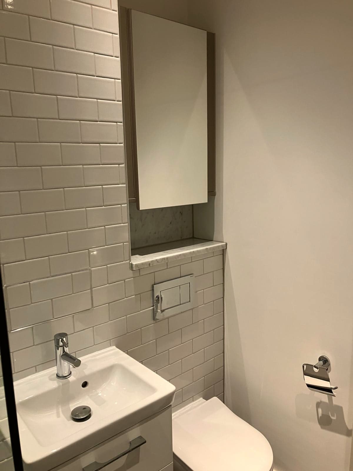 Mirror, basin and WC with a tiled shelf recess above, Marylebone W1