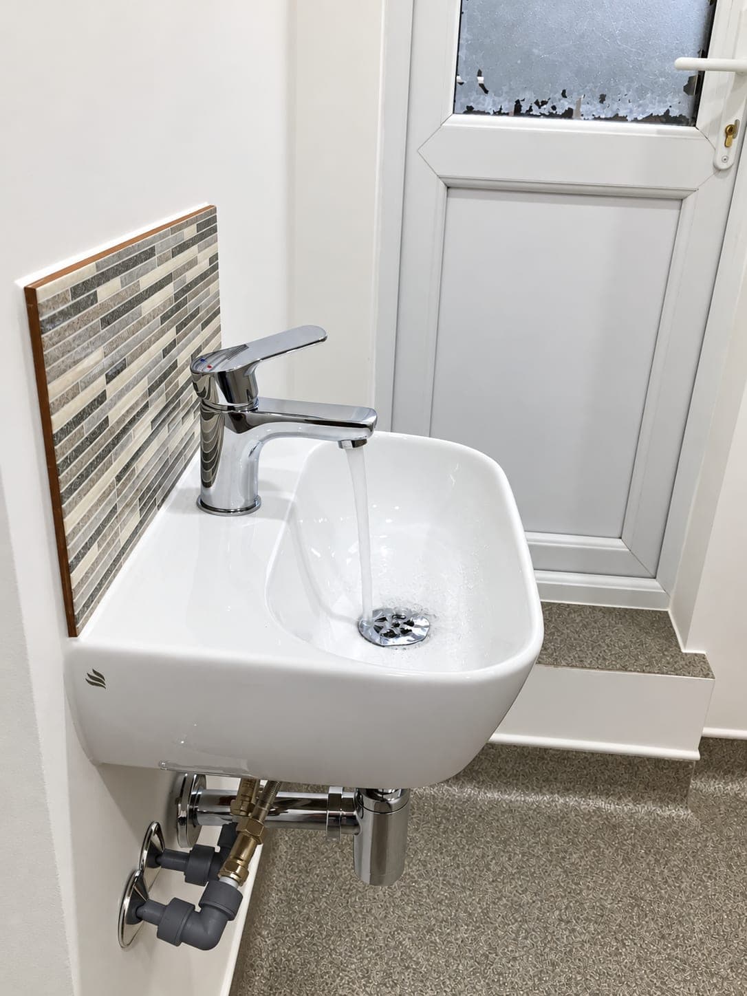 Wall-hung clinical hand basin with lever tap beside the door, Chiswick W4