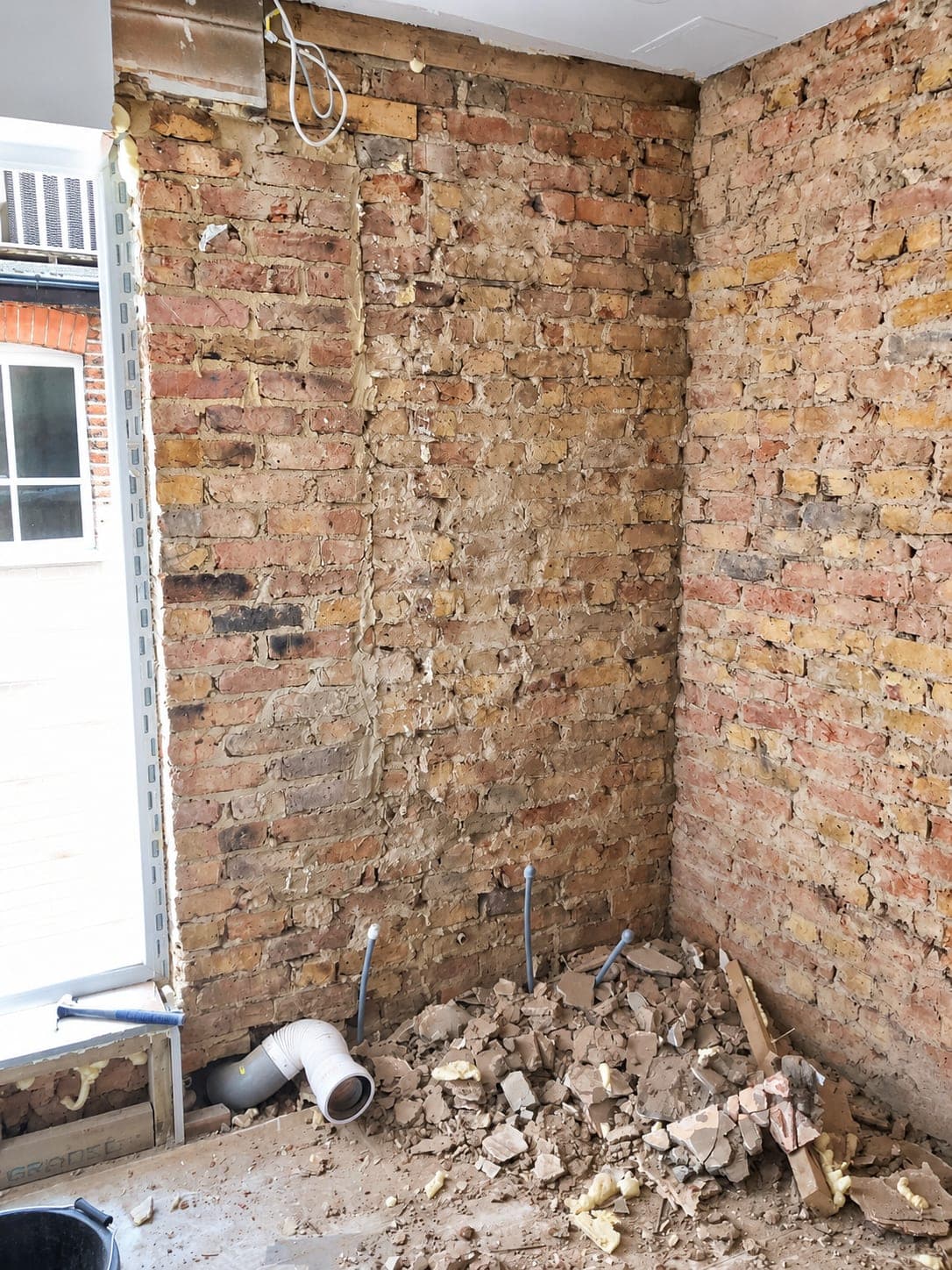 Room stripped back to bare brick before the fit-out, Chiswick W4