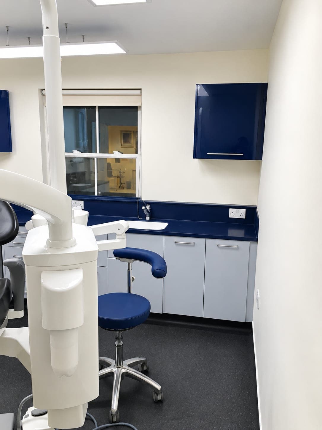 Surgery with navy wall units, worktop run and operator stool, Docklands E14
