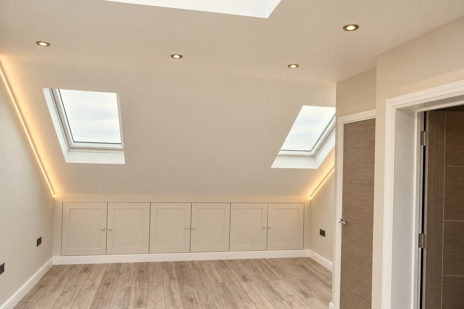Eaves storage and roof windows with concealed cove lighting along the ceiling line, Hampstead NW3