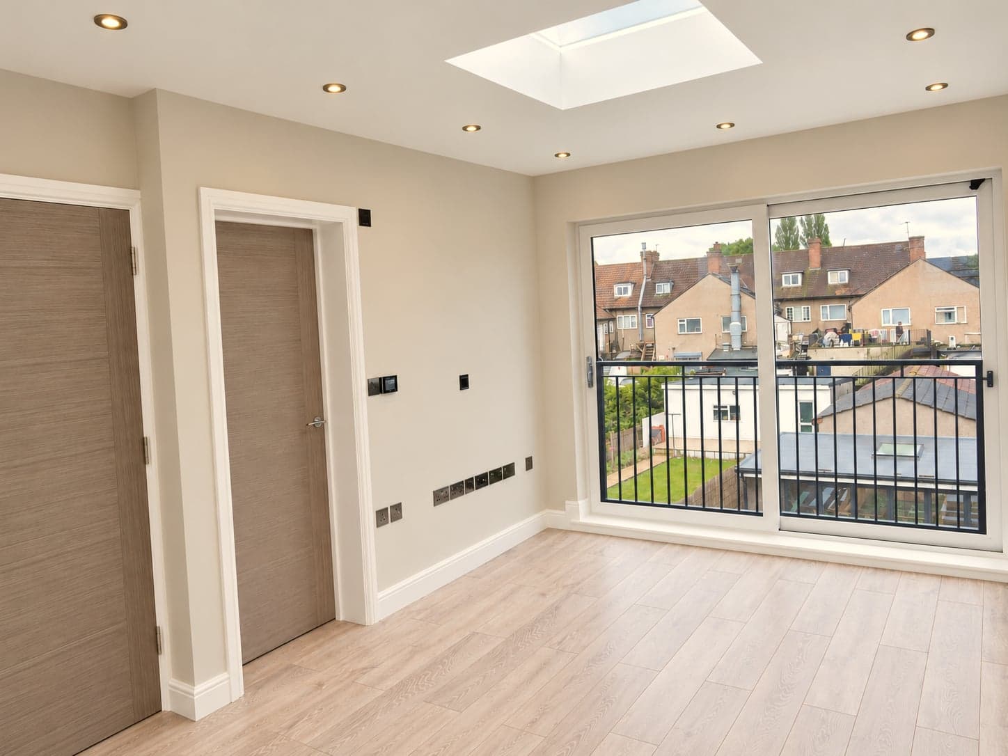 Loft bedroom looking out through the Juliet balcony doors, flush rooflight overhead, Hampstead NW3