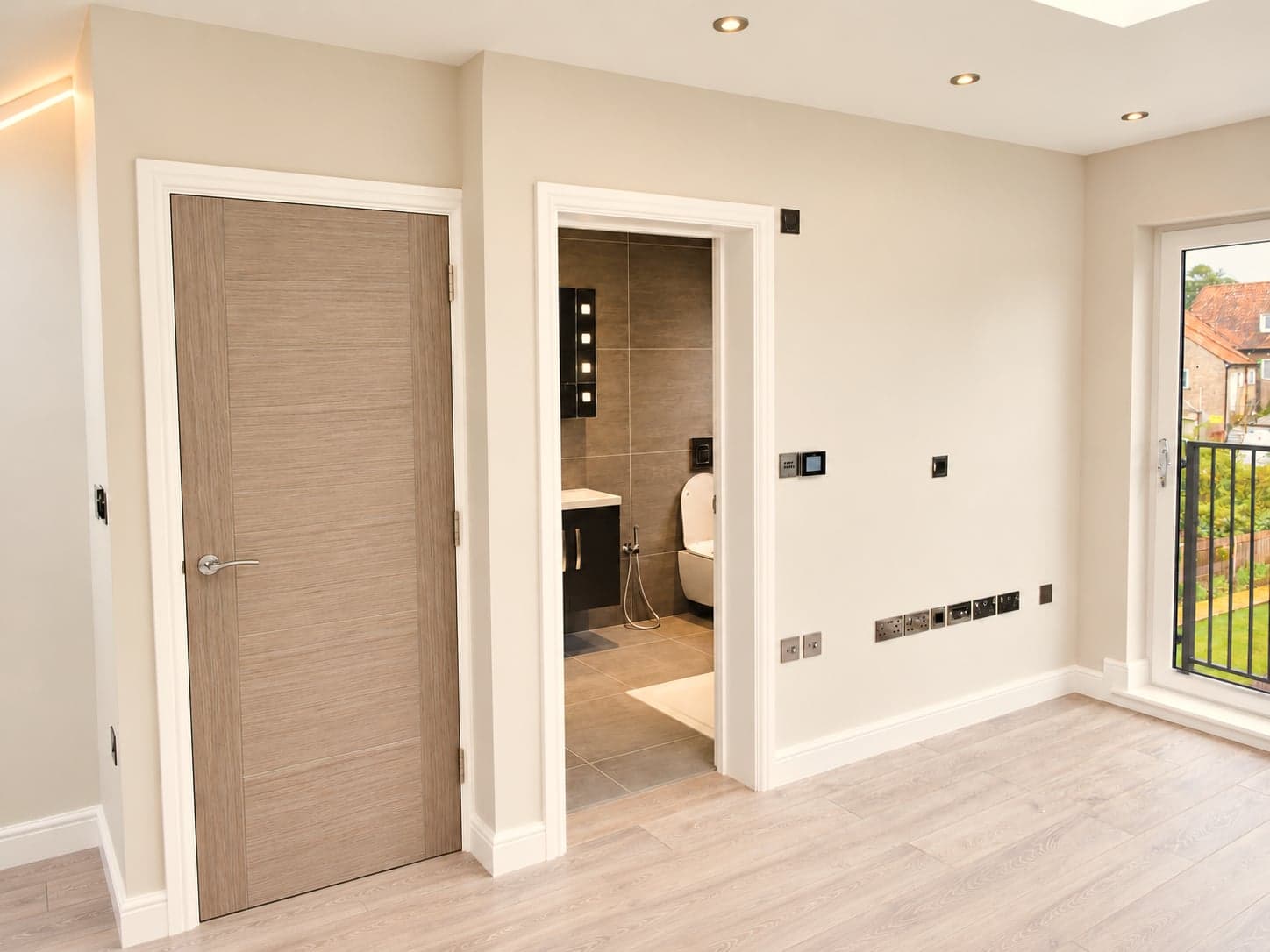Loft bedroom with the en-suite door open and the Juliet balcony beyond, Hampstead NW3