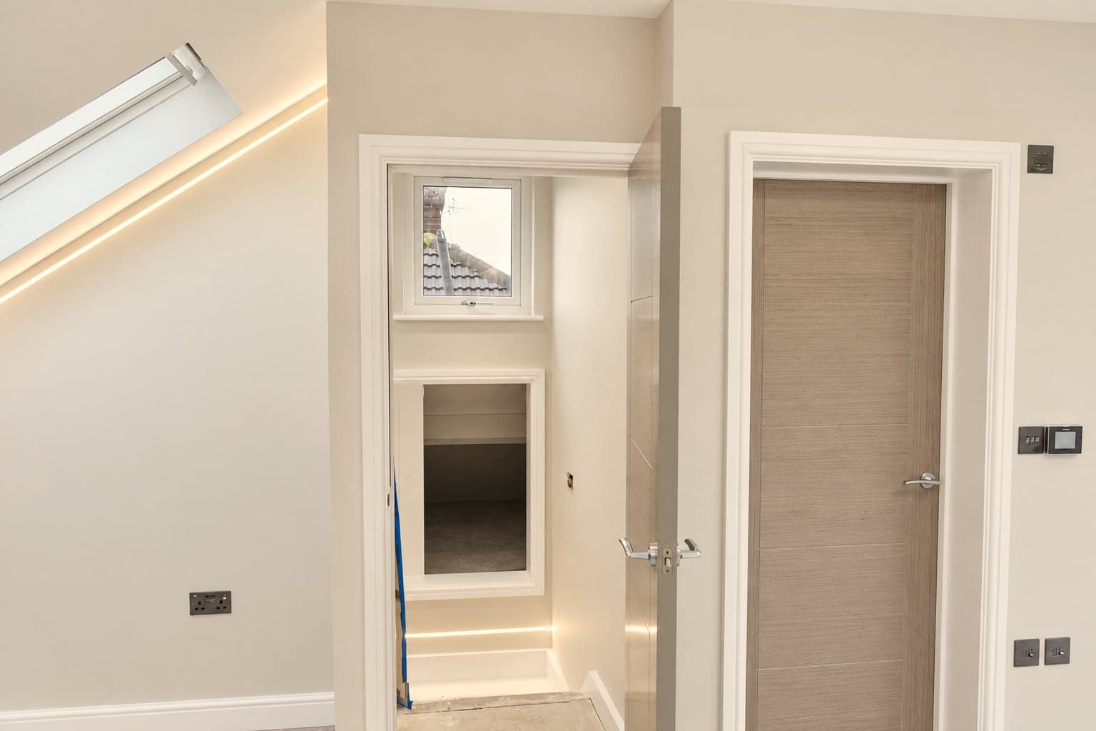 Roof window and storage hatch beside the door, concealed lighting above, Hampstead NW3