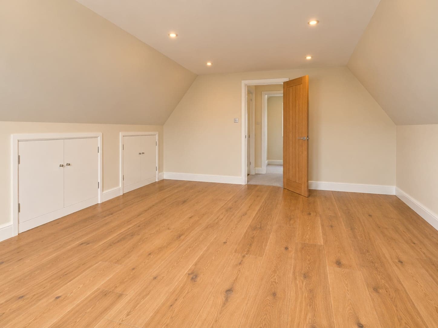 Loft room looking back to the door, sloping ceiling and oak floor, Watford WD17