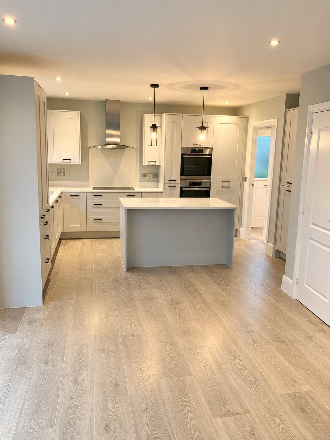 Full kitchen with island, chimney extractor and oven tower along one wall, Shepherds Bush W12