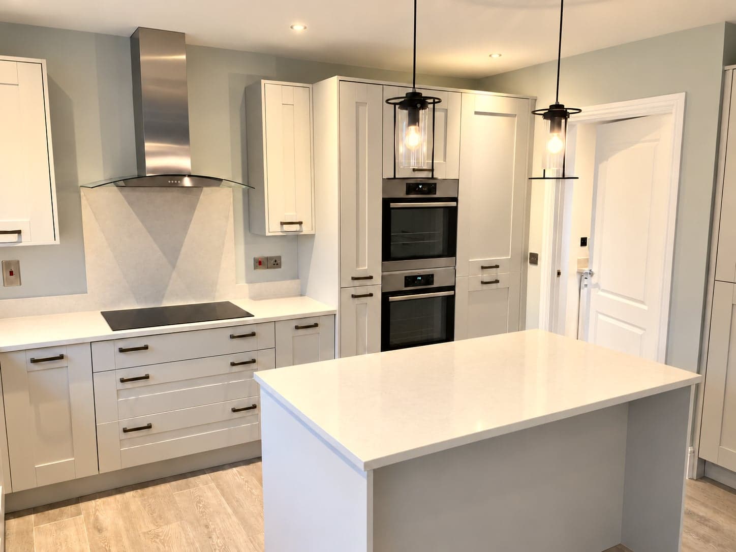 Induction hob under the stainless chimney extractor with the island in front, Shepherds Bush W12