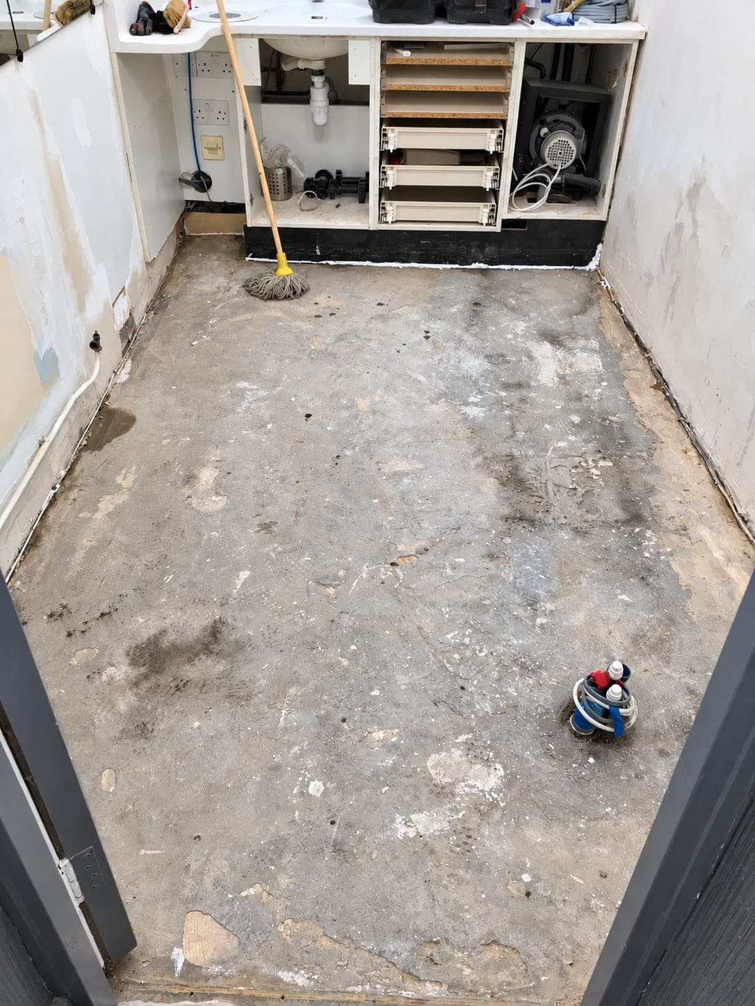 Surgery stripped out with the old cabinetry exposed and floor lifted, Finchley N3