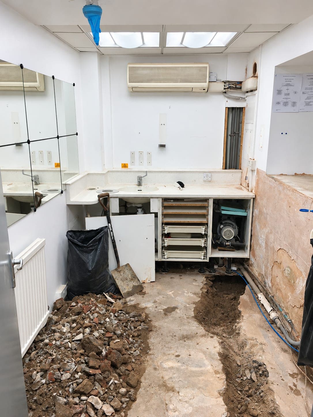 Cabinetry pulled away and the floor dug out to re-run services, Finchley N3