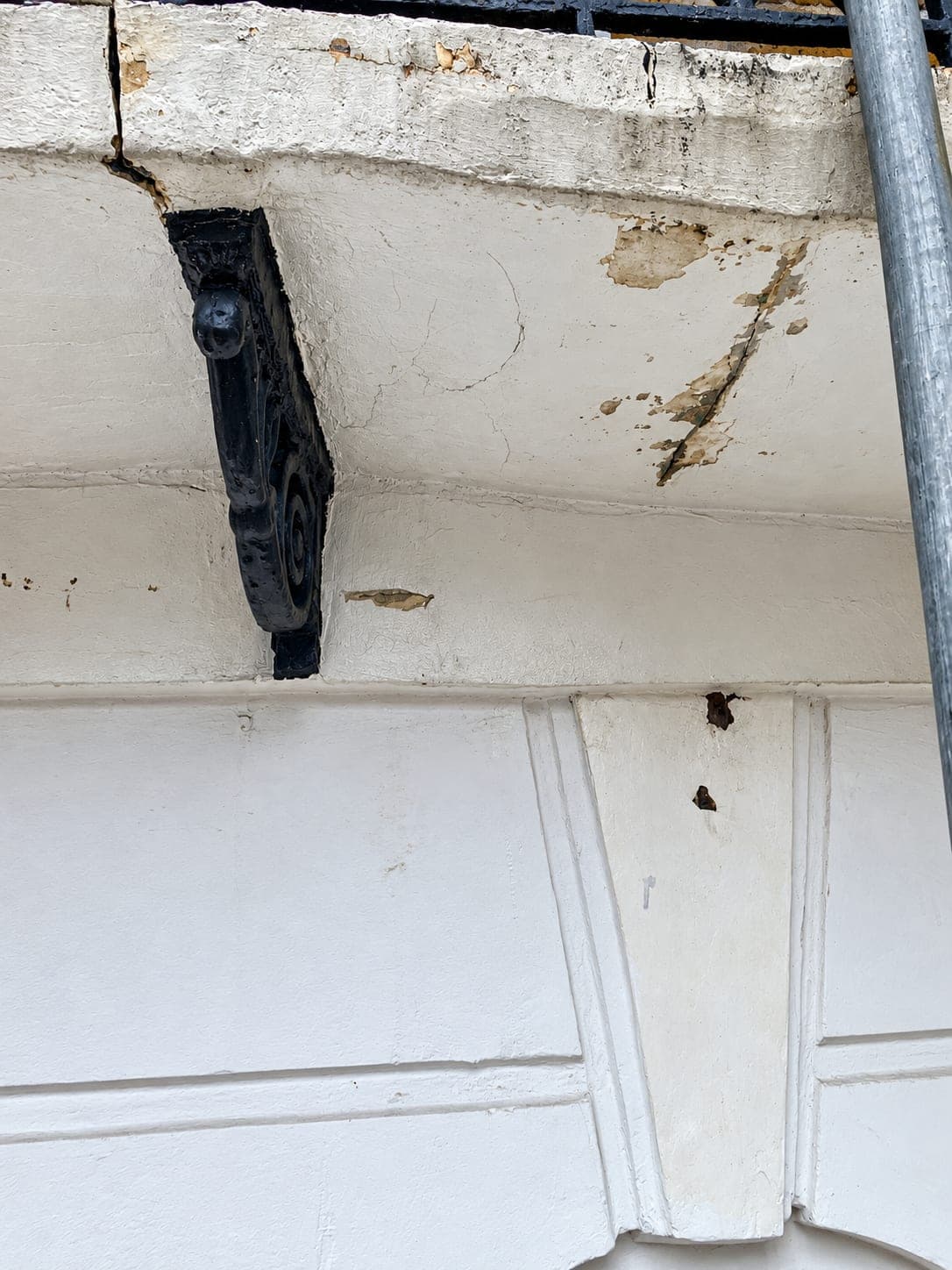 Cracked stucco cornice and console bracket before repair, Shepherdess Walk N1