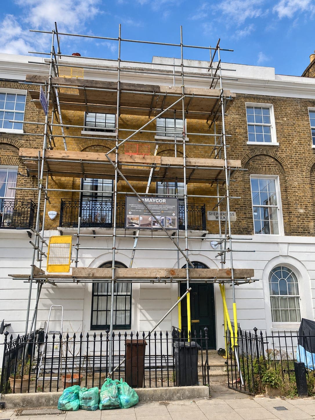 Georgian terrace front under scaffold during the stucco repairs, Shepherdess Walk N1
