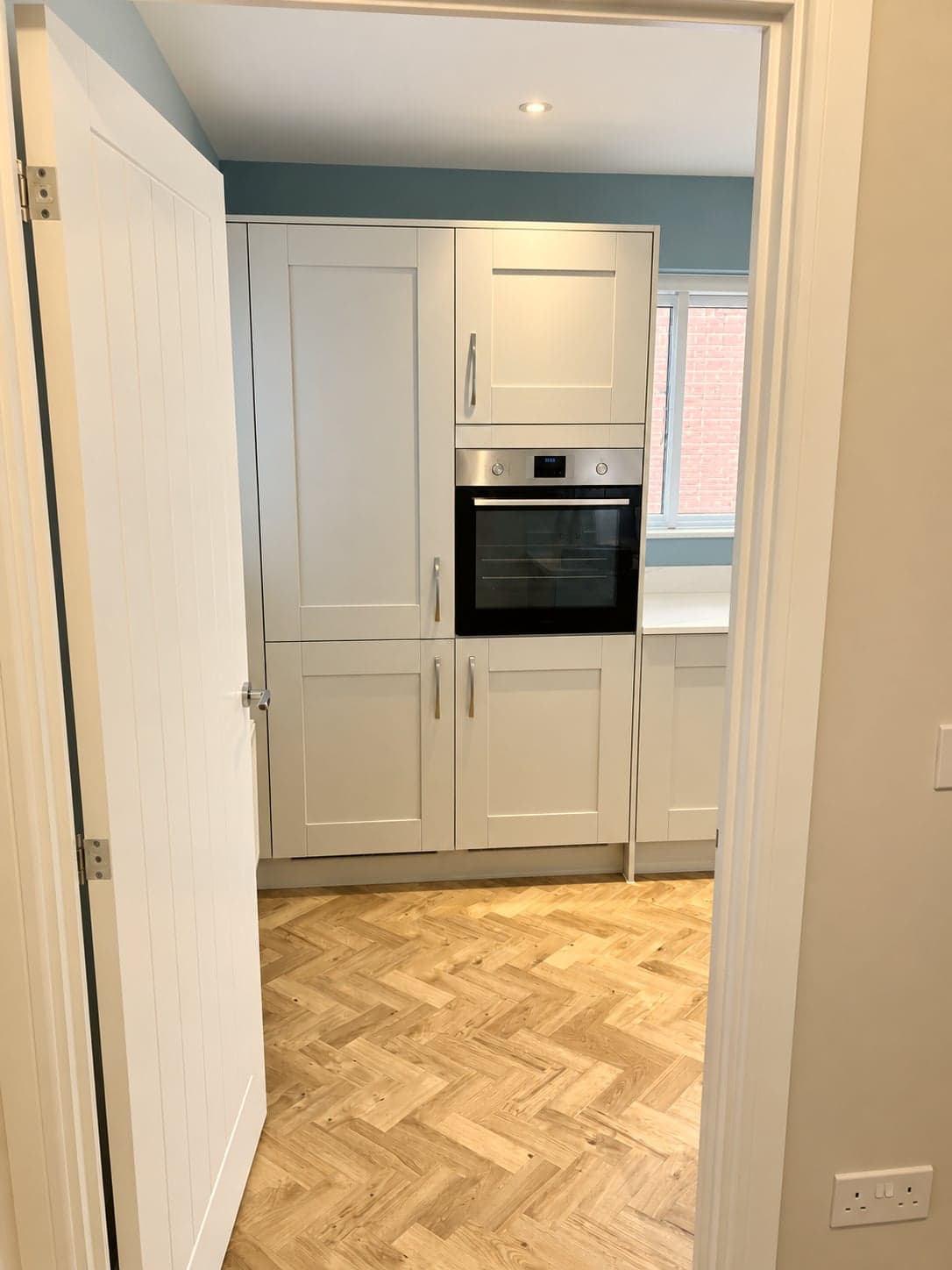 Kitchen seen from the hall with the oven tower and parquet floor beyond, Amersham HP6