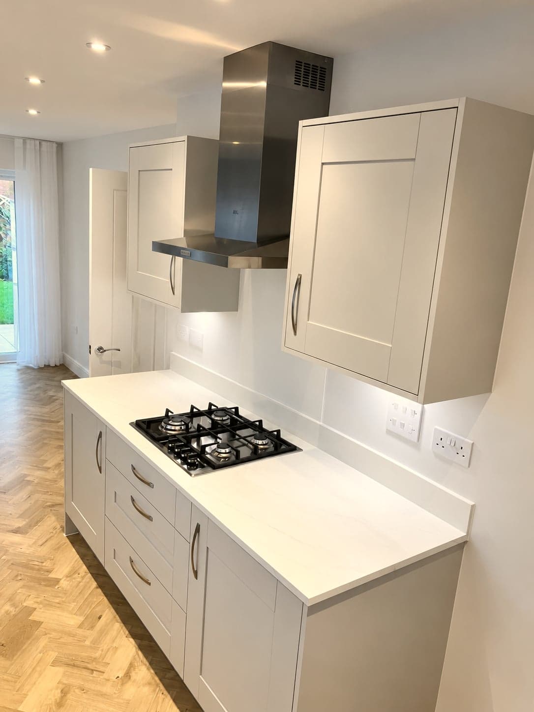 Island hob with stainless chimney extractor above and quartz worktop, Amersham HP6