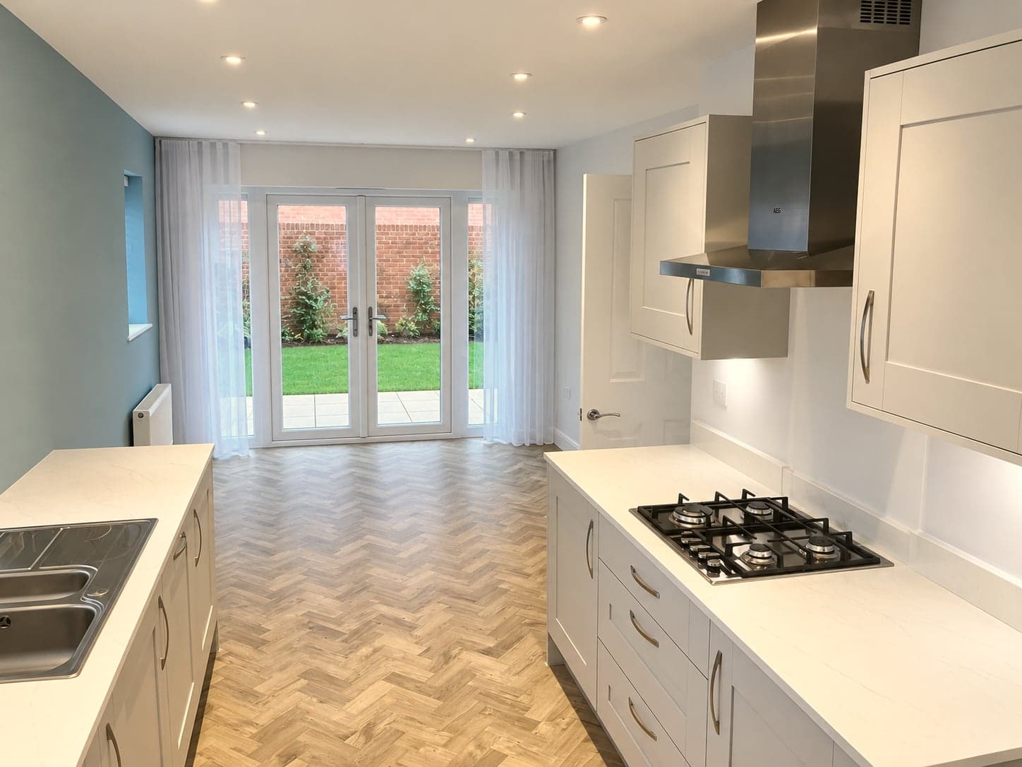Kitchen from the hall end: island hob, extractor and garden doors, Amersham HP6