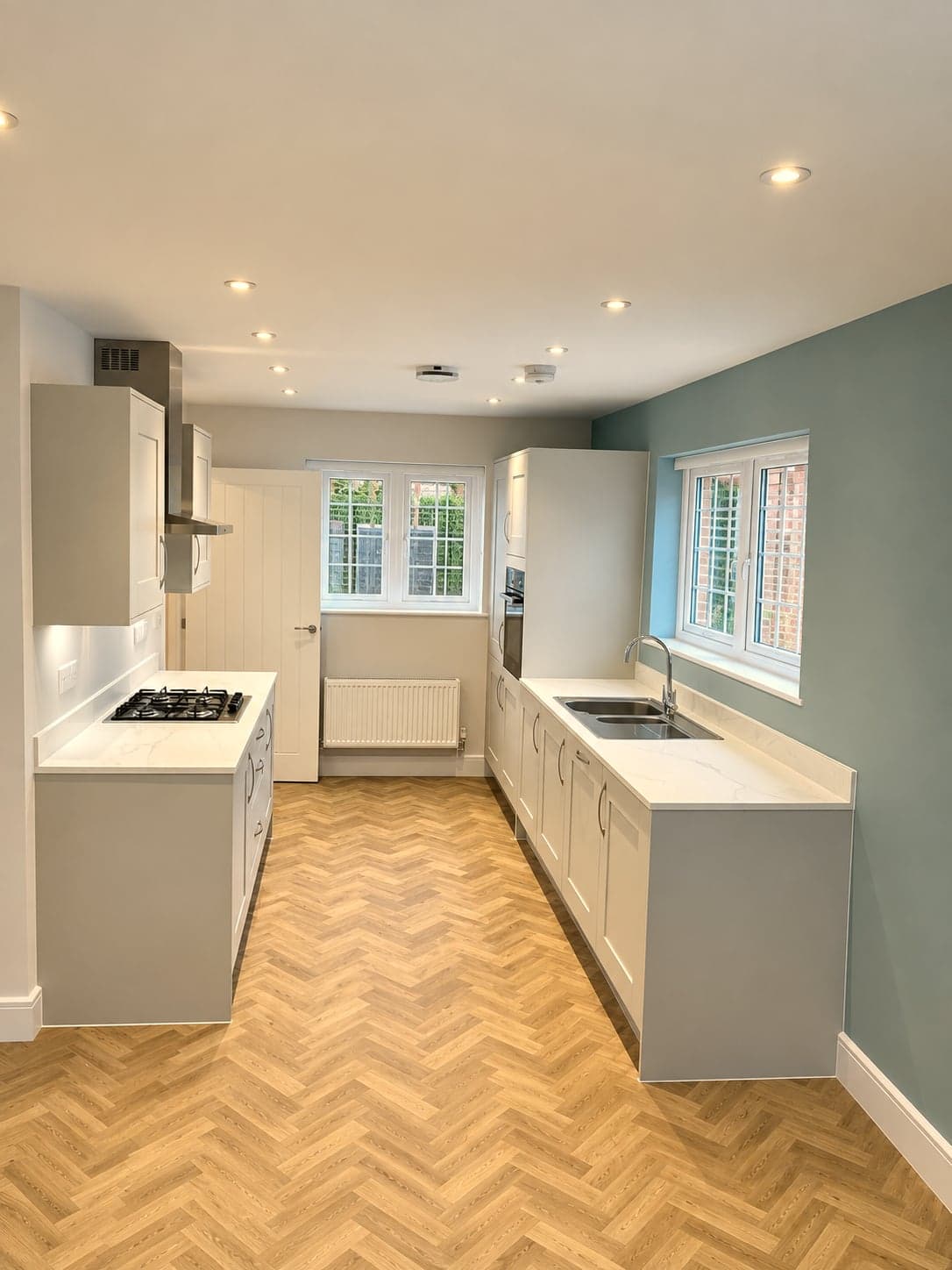 Grey shaker kitchen renovation with teal accent wall and herringbone floor, Amersham HP6