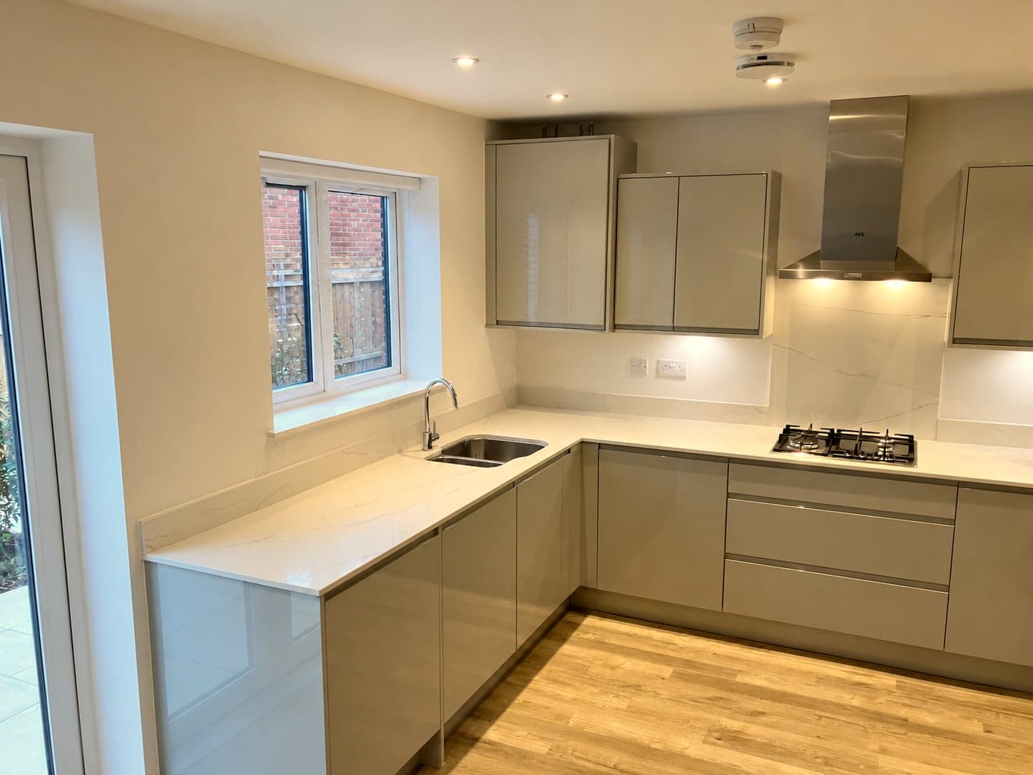Kitchen run along the window with handleless units and quartz worktop, Battersea SW11