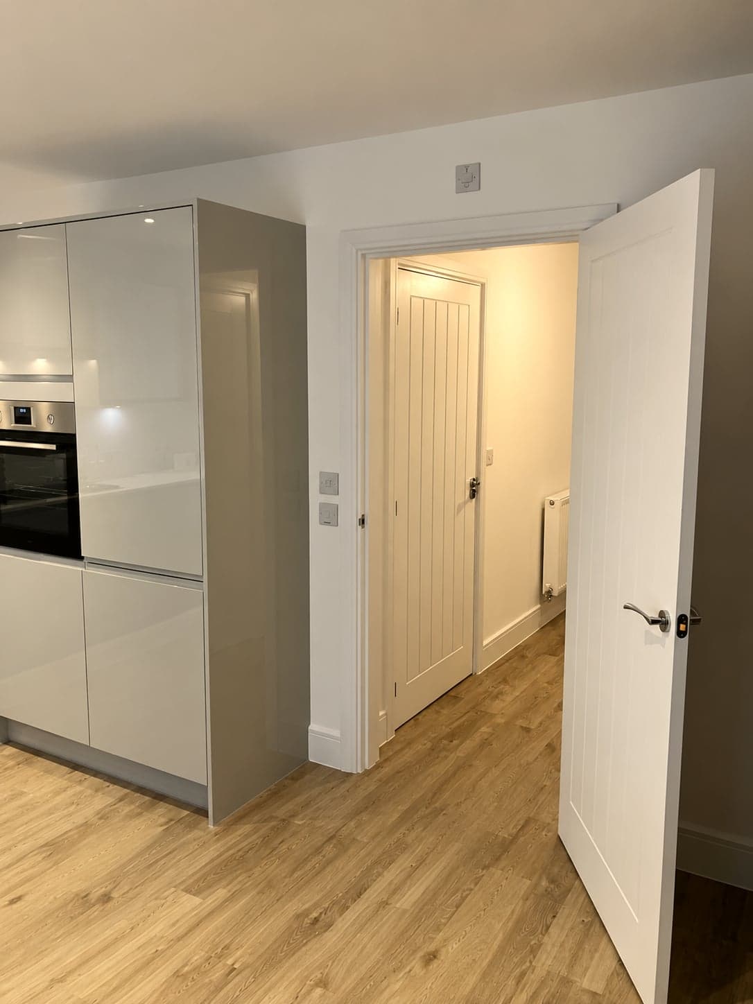 Handleless tall units with the door through to the hall, Battersea SW11