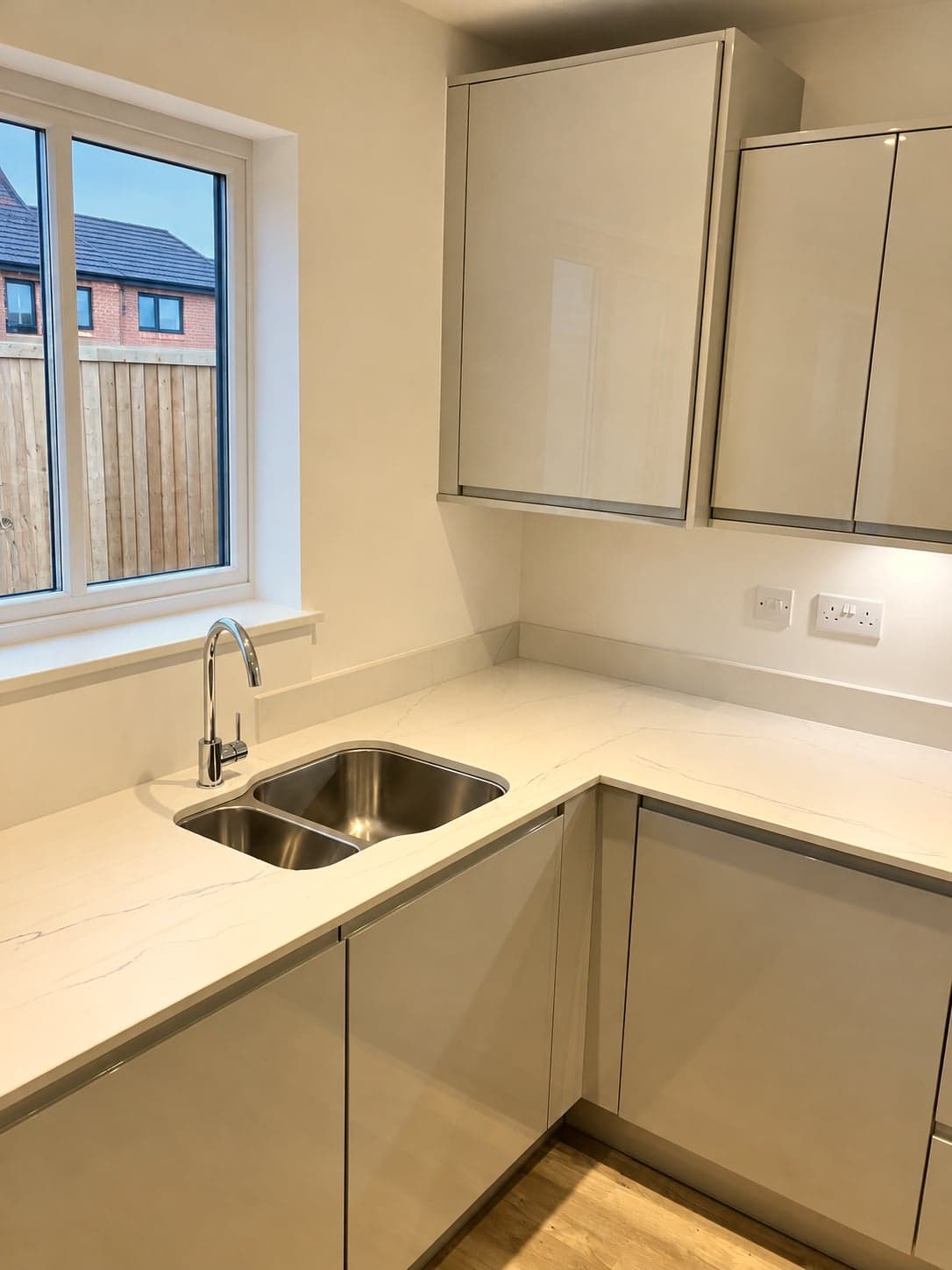 Inset sink and quartz worktop wrapping the corner below the window, Battersea SW11