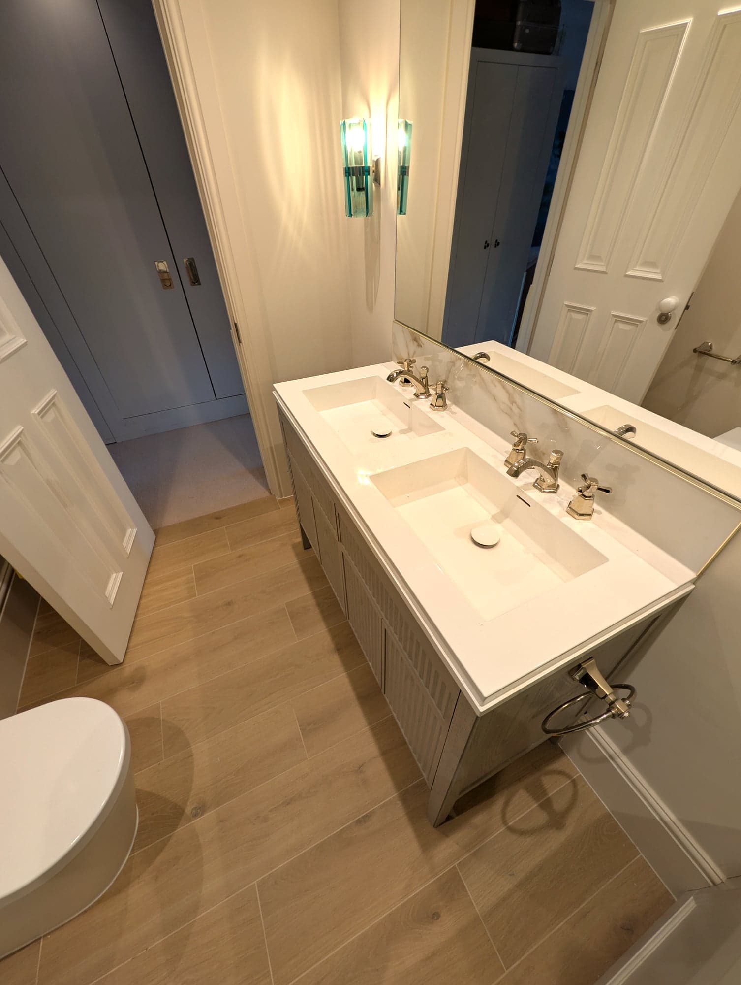 Double vanity seen from the doorway, oak flooring and painted panelled door, Fulham SW6