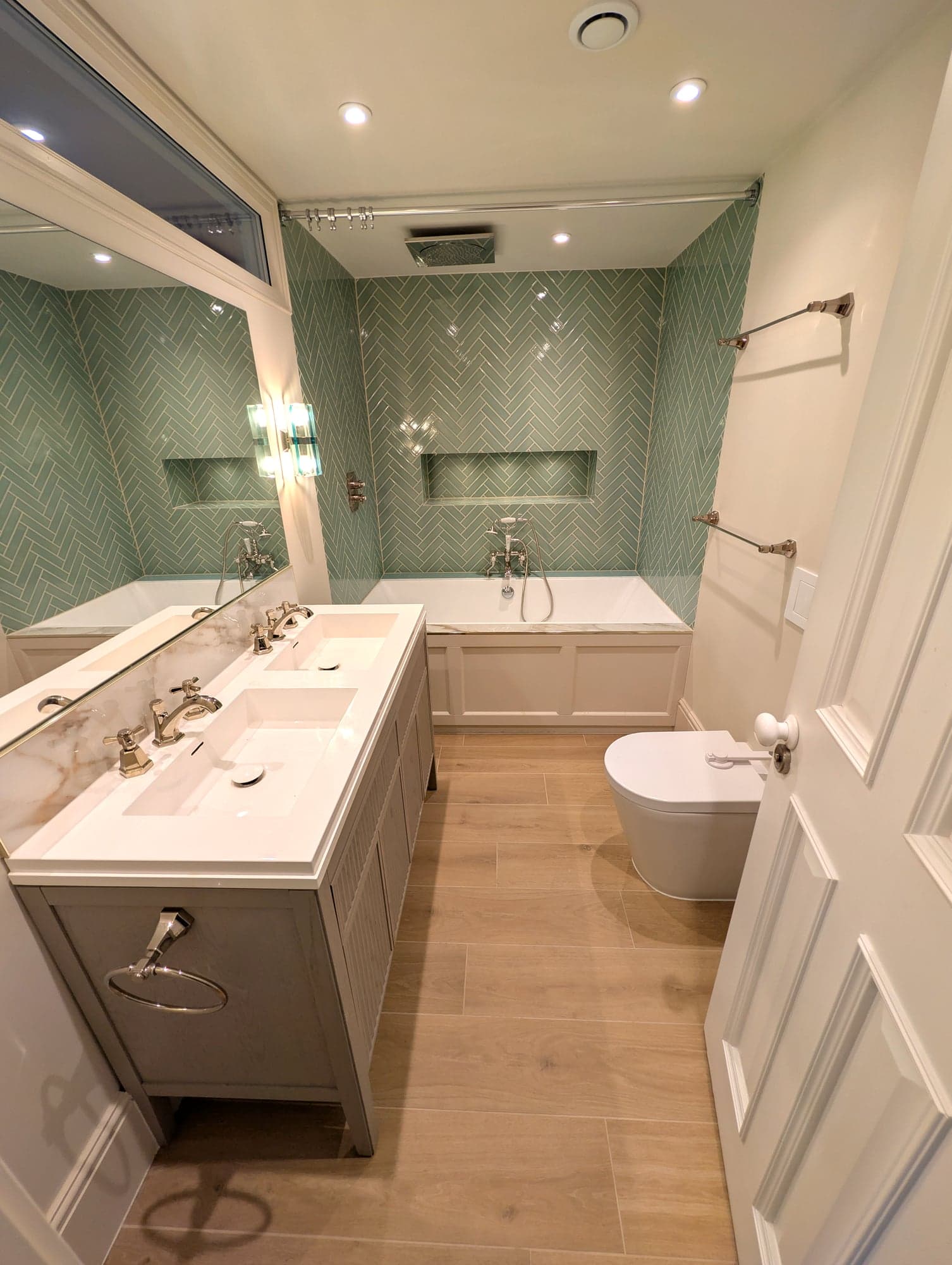 Vanity and bath alcove with glass wall lights either side of the mirror, Fulham SW6