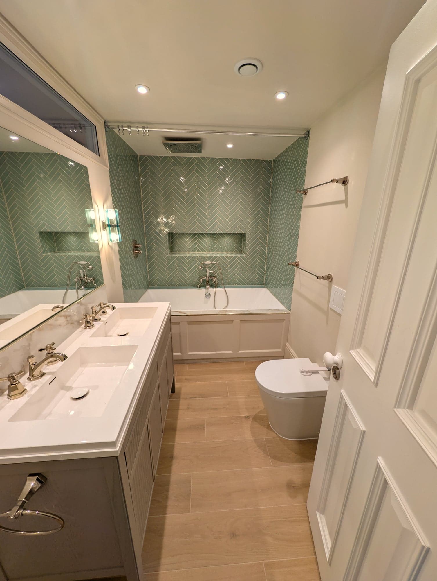 Vanity, bath and WC framed by the open panelled door, Fulham SW6