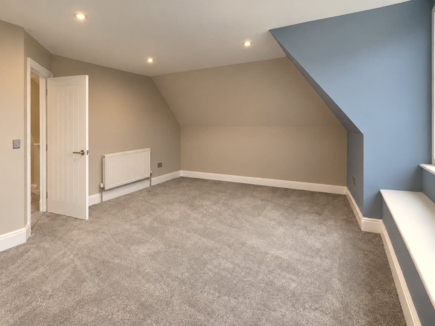 Loft room looking back to the door, sloping ceiling and radiator under the eaves, Mill Hill NW7