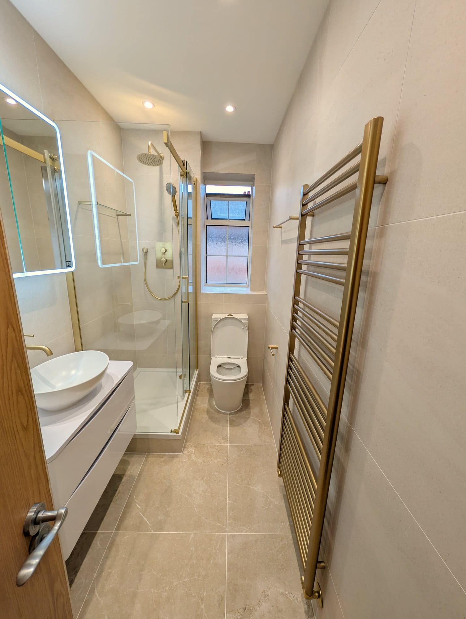 Full length of the bathroom: vanity, shower, WC and brass heated towel rail, Nine Elms SW8